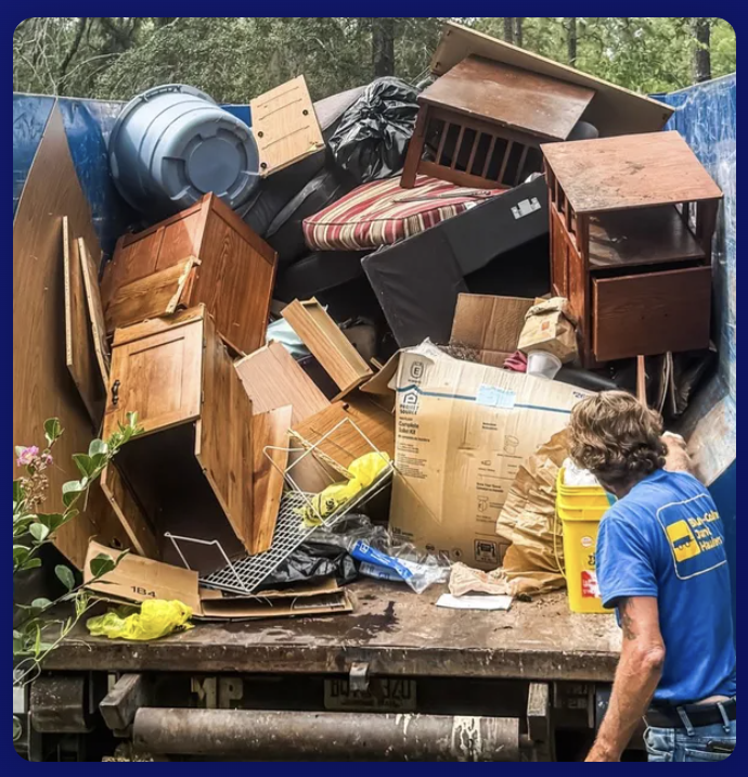 Pile of junk being loaded into dumpster